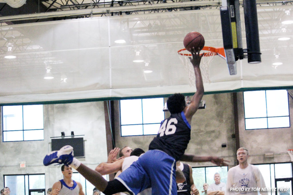 Justin Patton uses his height to go nearly horizontal towards the rim and tip in a teammate's miss. (Photo by Tom Nemitz / WBR)